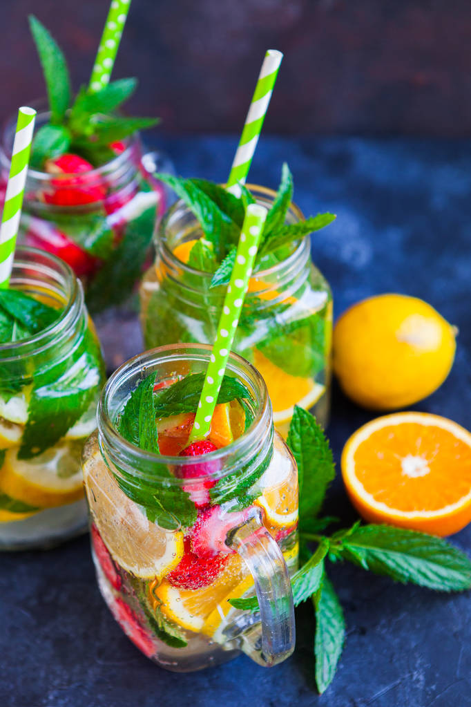 Verse limonade met zomer fruit en bessen op donkere concrete achtergrond - Foto, afbeelding