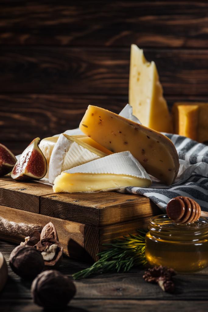 erityyppiset juustot, hunaja ja viikuna pöydällä
 - Valokuva, kuva