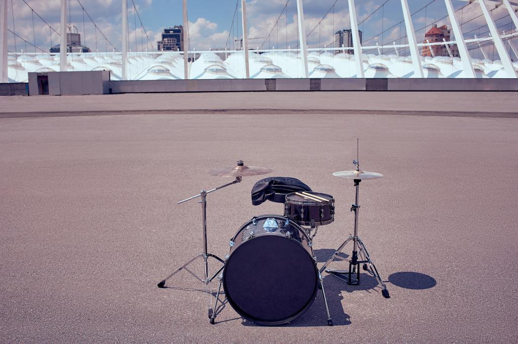 крупный план черного барабанного комплекта и барабанных палочек на улице
 - Фото, изображение