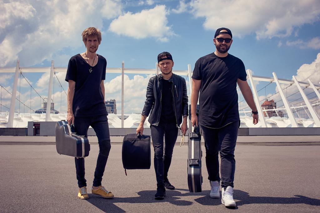 mladí hudebníci s hudebními nástroji v případech chůzi na ulici s zatažené obloze na pozadí - Fotografie, Obrázek