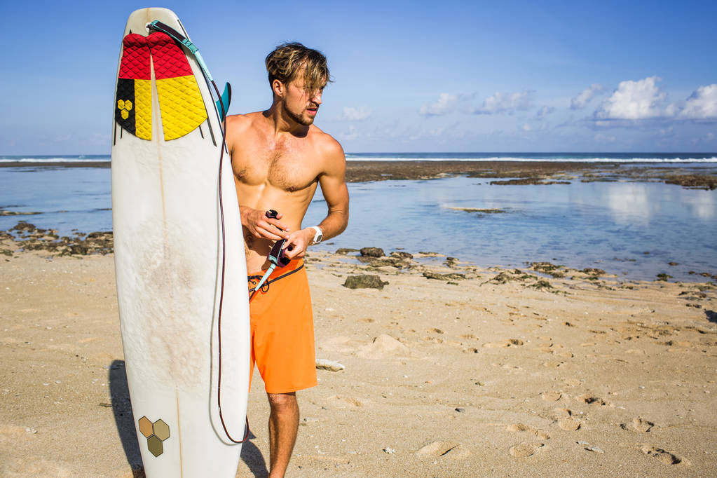 jovem com prancha de surf na praia perto do oceano
 - Foto, Imagem