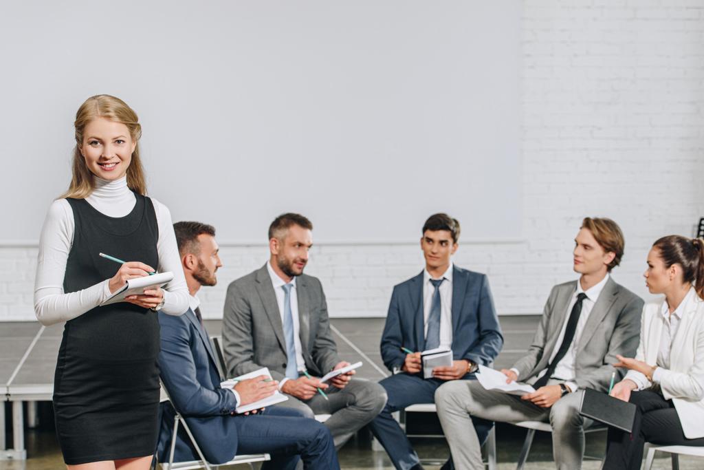 kaunis liiketoiminnan valmentaja seisoo edessä liikemiesten koulutuksessa napa
 - Valokuva, kuva