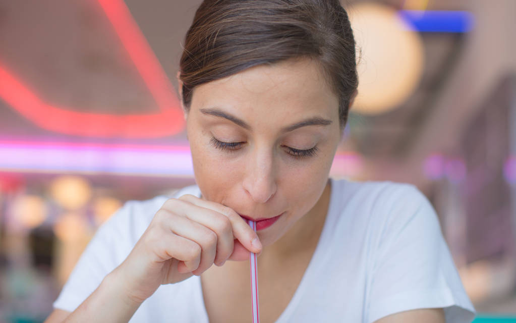 joven bonita mujer feliz y satisfecha bebiendo una cola en un restaurante americano
 - Foto, imagen