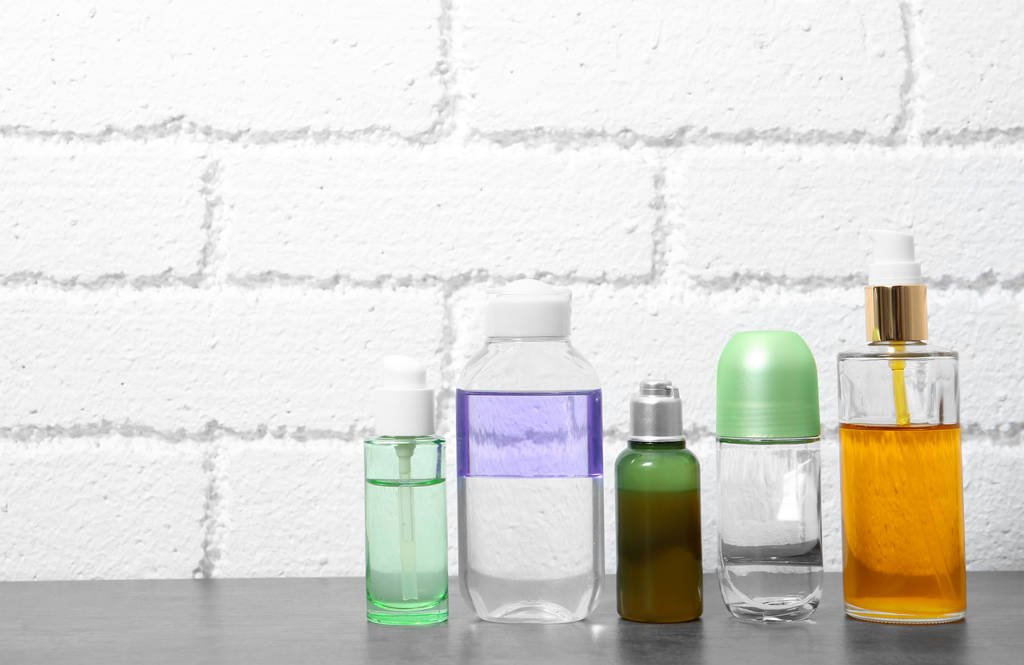 Verschillende cosmetische producten op tafel tegen muur - Foto, afbeelding