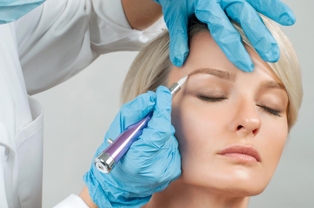 Sobrancelhas Microblading. Cosmetologist fazendo maquiagem permanente. Mulher atraente recebendo cuidados faciais no salão de beleza
 - Foto, Imagem