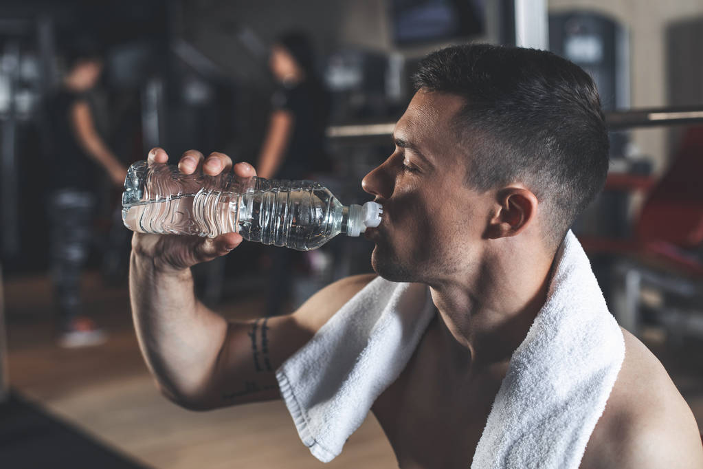 Спортсмен пьет воду в помещении
 - Фото, изображение
