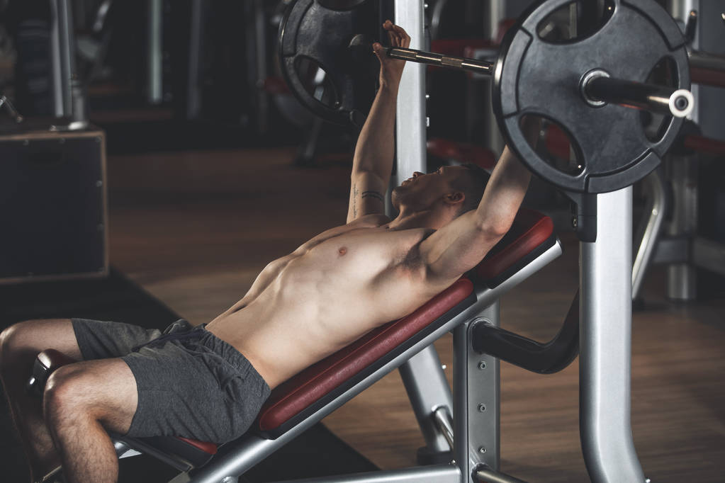 Sportowiec wykonuje z maszyny i waga w siłowni - Zdjęcie, obraz