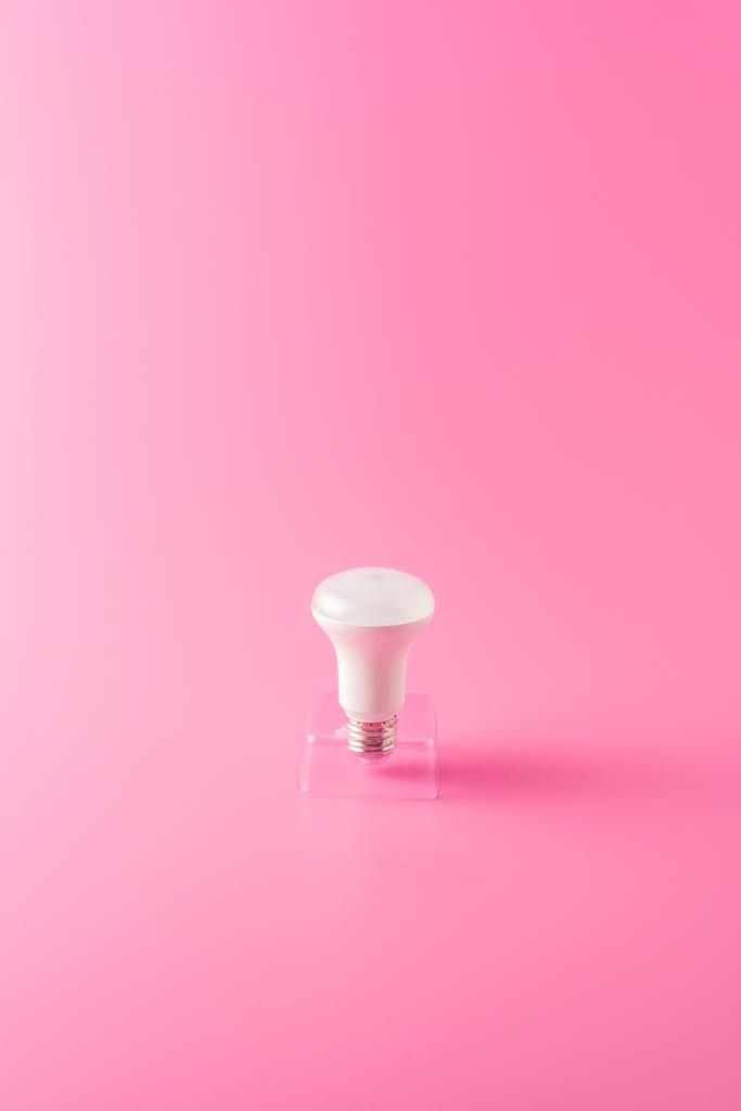 крупним планом вид однієї лампочки на рожевому фоні
 - Фото, зображення
