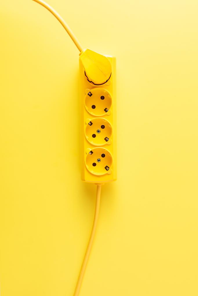 ylhäältä näkymä kirkkaan keltainen pistorasia pistorasiaan pistoke keltaisella taustalla
 - Valokuva, kuva