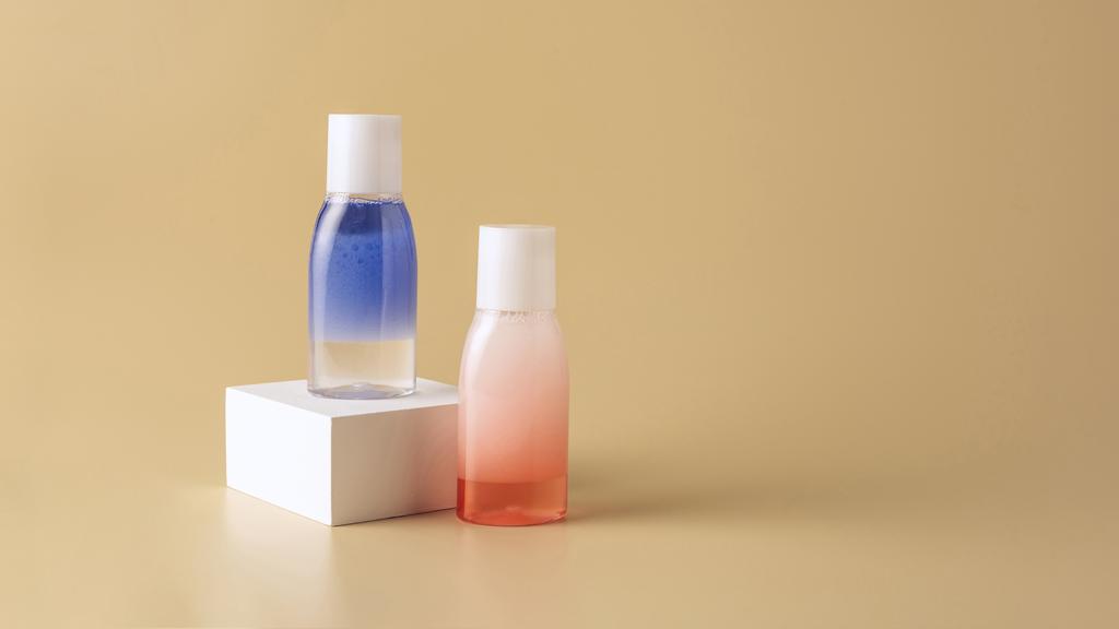 primer plano vista de lavado facial en botellas en cubo blanco sobre fondo beige
 - Foto, imagen