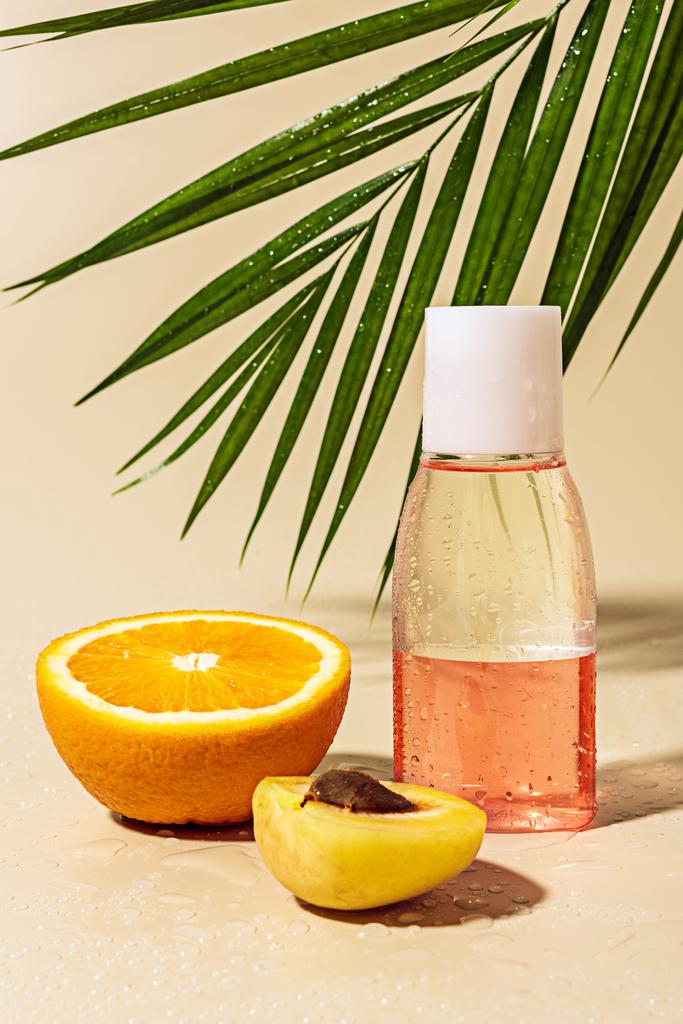 close up view of micellar water for skin care in bottle and orange half with water drops on beige background - Photo, Image