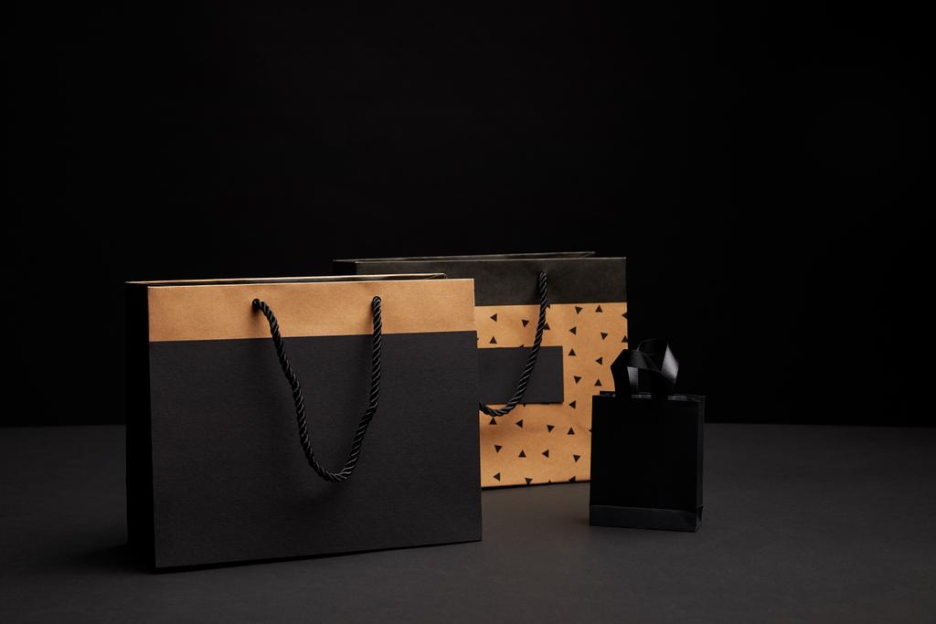 Alışveriş torbaları siyah arka plan üzerine düzenlenmiş görünümünü kapat - Fotoğraf, Görsel