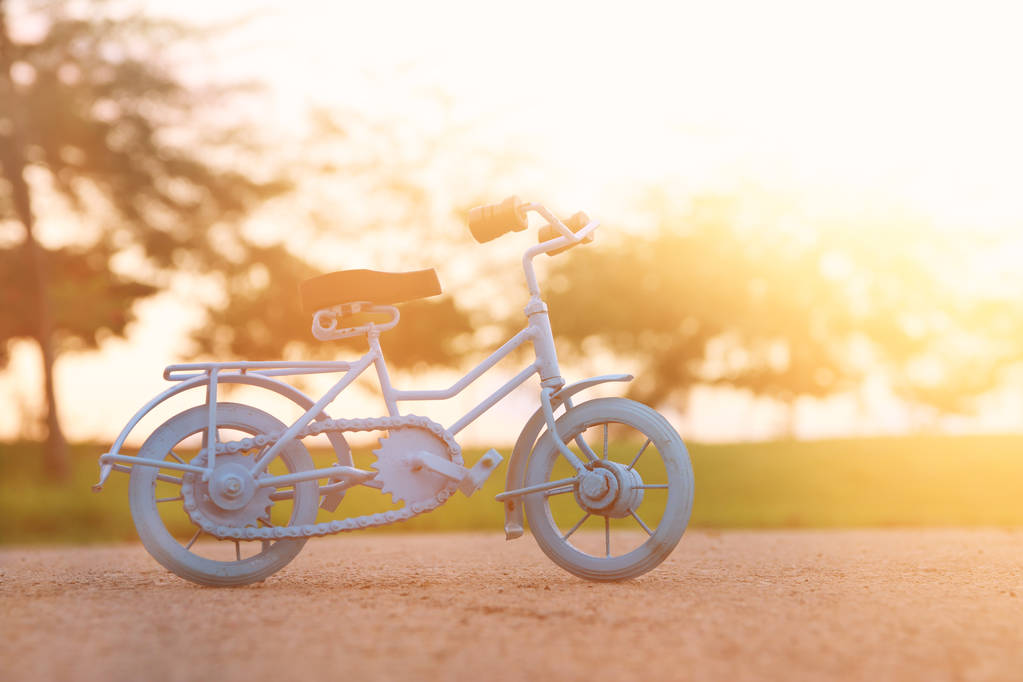 Jouet vélo vintage bleu attendant à l'extérieur à la lumière du coucher du soleil
 - Photo, image