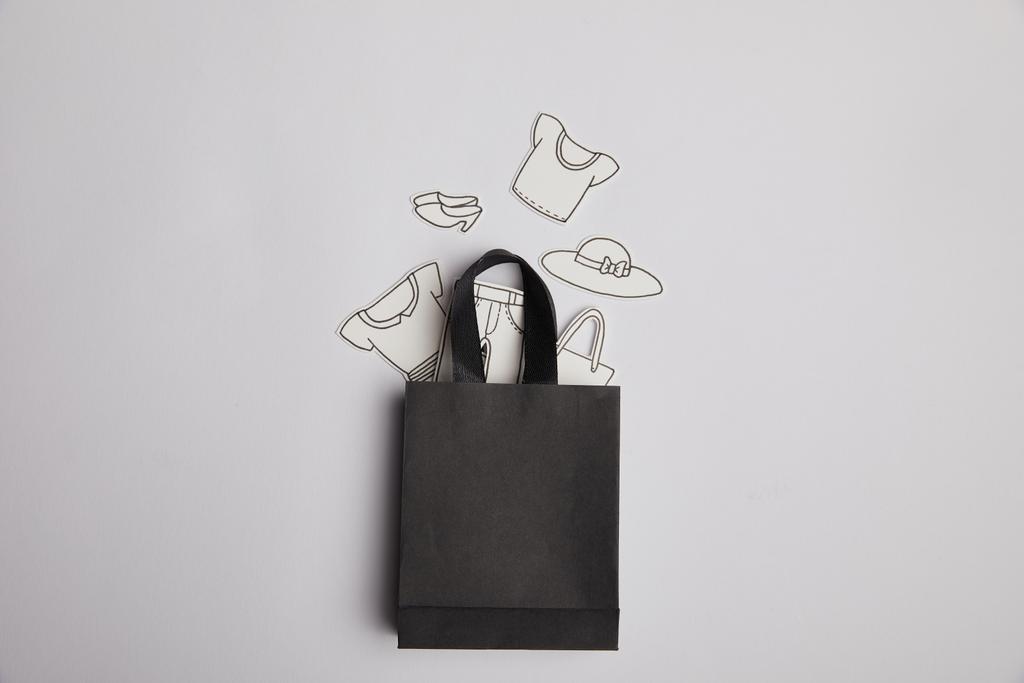 Konsept alışveriş gri arka plan üzerinde siyah alışveriş çantası ve kağıt giyim üstten görünüm - Fotoğraf, Görsel