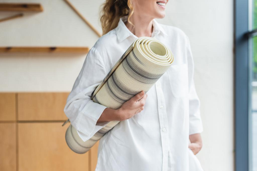 corte tiro de sorrir mulher madura segurando tapete de ioga
 - Foto, Imagem