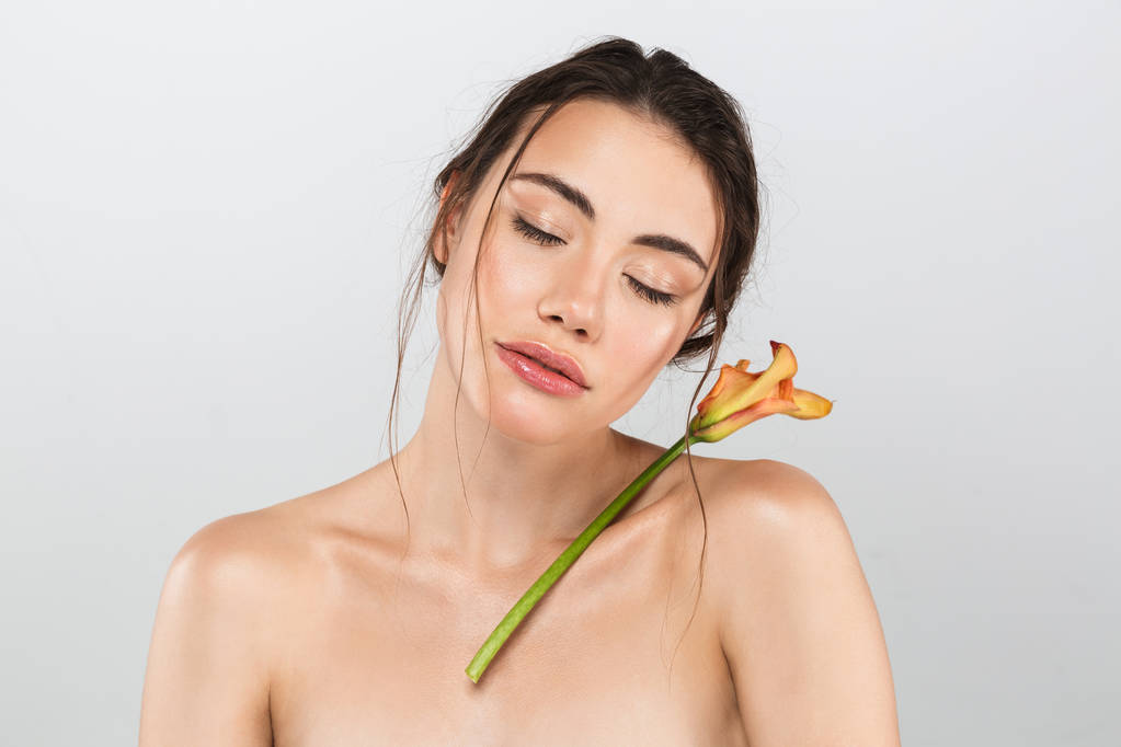 Красота портрет красивой молодой топлесс женщина с макияжем позируя с лилией цветок на ее лицо изолированы на сером фоне
 - Фото, изображение