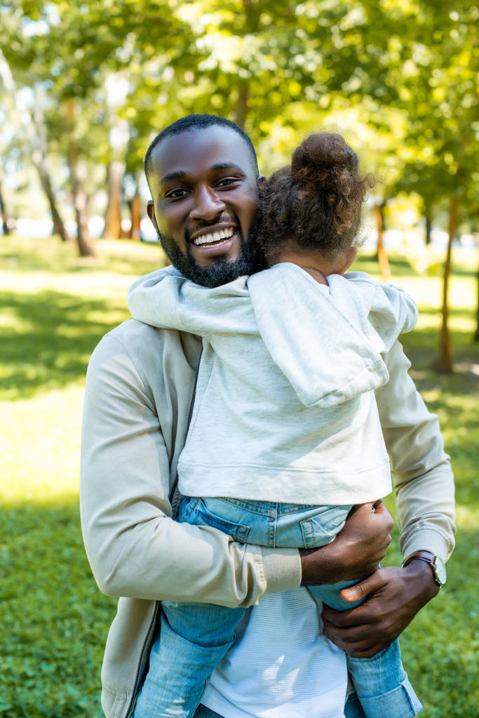 boldog afro-amerikai apja átölelve lánya park - Fotó, kép