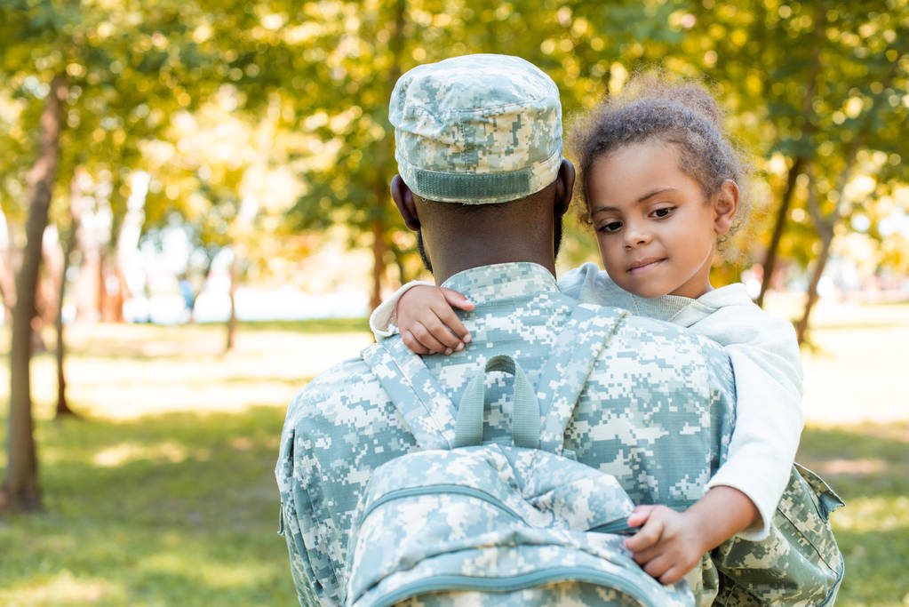Afrika kökenli Amerikalı asker askeri üniforma holding kız parkta - Fotoğraf, Görsel