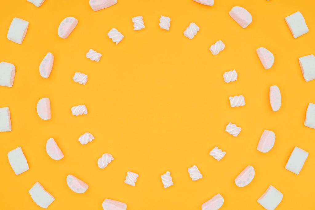 vista superior de los círculos de deliciosos malvaviscos aislados en naranja
 - Foto, imagen