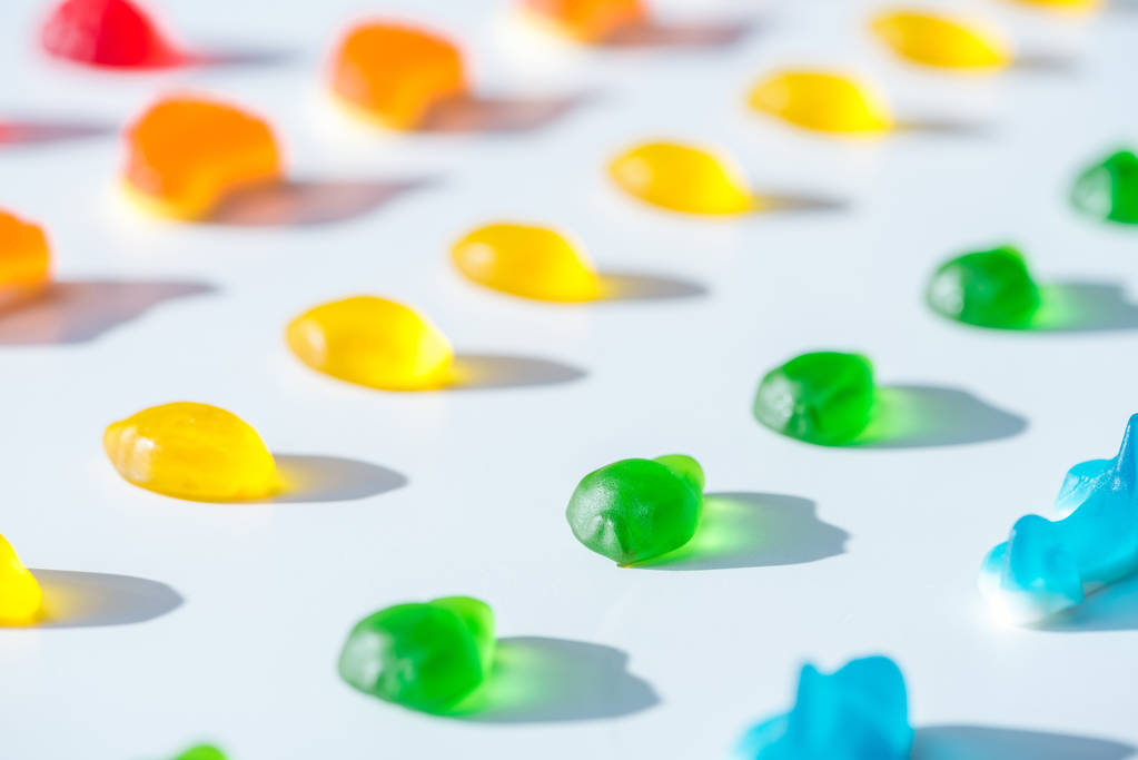 set van zoete gele, groene en blauwe jelly snoepjes op wit - Foto, afbeelding