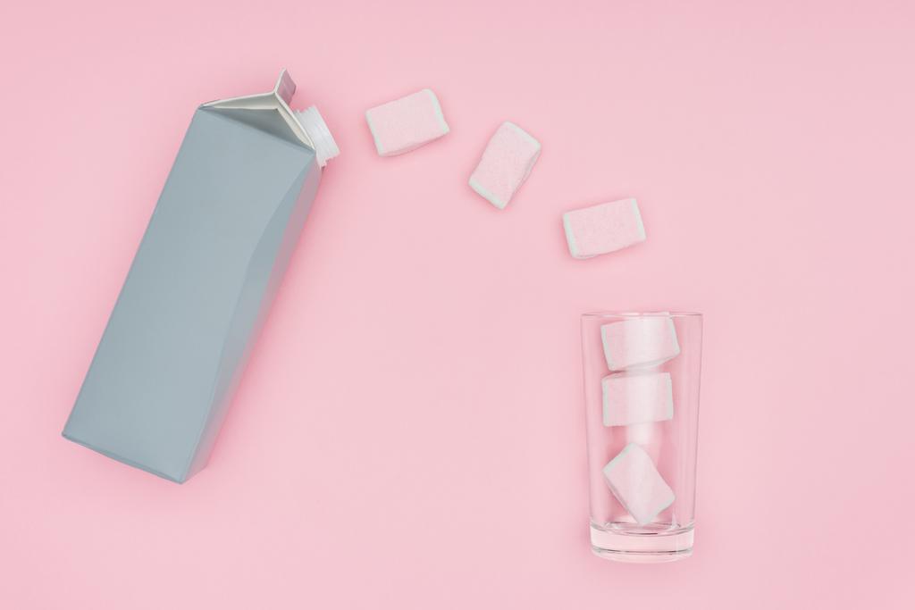 top view of marshmallows, glass and carton package isolated on pink  - Photo, Image