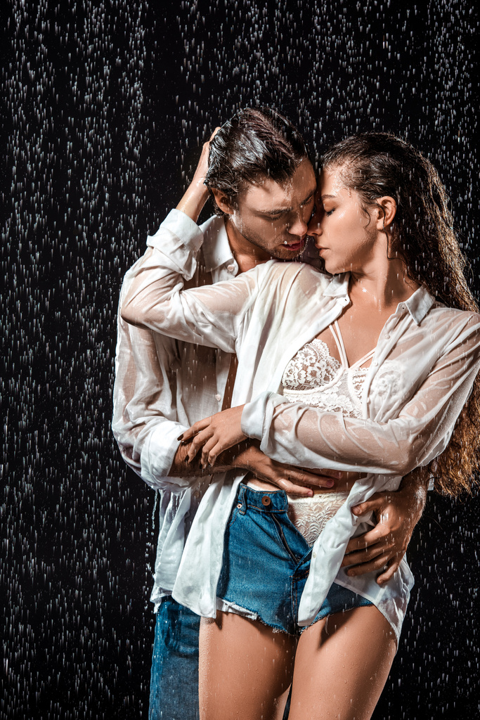 baştan çıkarıcı çift siyah izole yağmur altında sarılma portresi - Fotoğraf, Görsel
