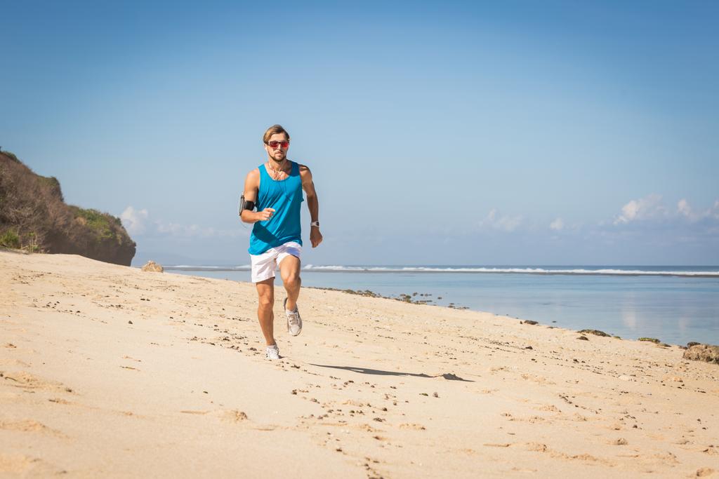 спортсмен працює на піщаному пляжі біля моря, Балі, Індонезія - Фото, зображення