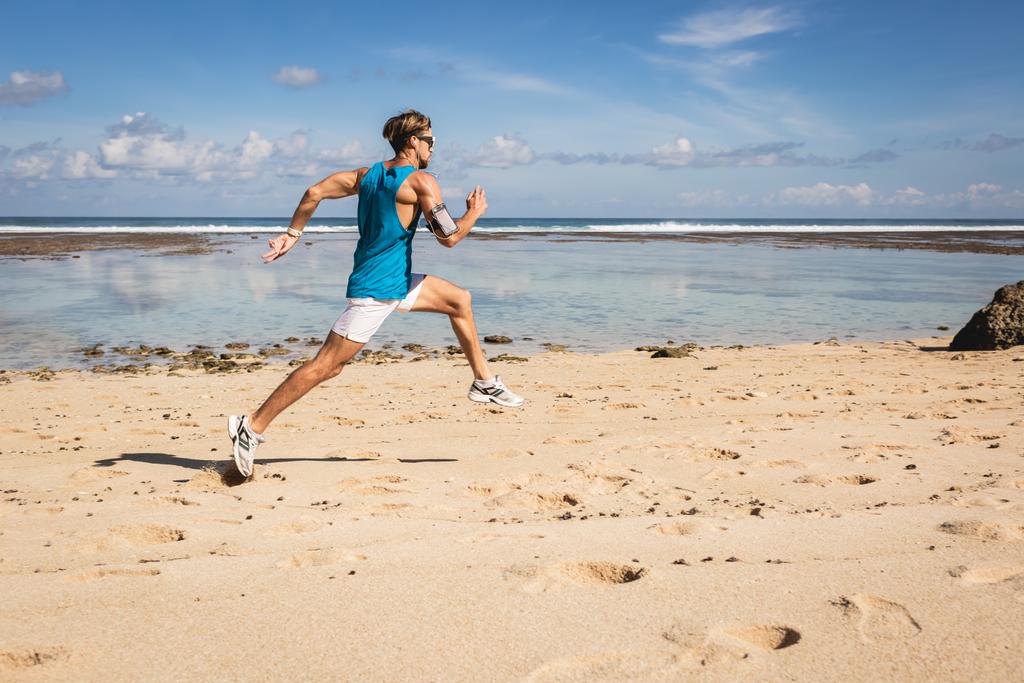 athletischer mann läuft und springt am sandstrand in meernähe, bali, indonesien - Foto, Bild