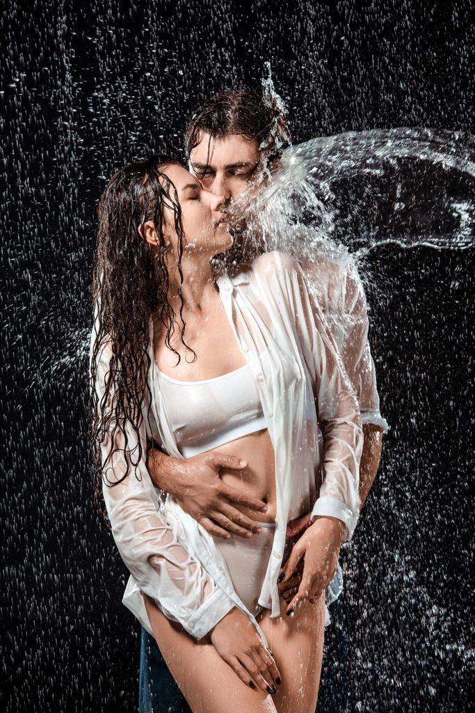 portrait of seductive couple swilled with water isolated on black - Photo, Image