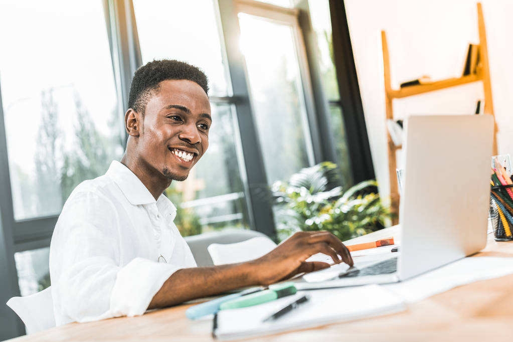 アフリカ アメリカ人実業家の office で作業しながらノート パソコンで入力を笑顔の肖像画 - 写真・画像