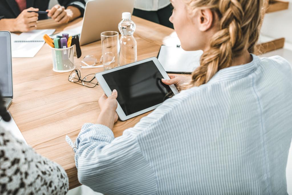 Dijital tablet meslektaşları ile toplantı sırasında masada otururken holding iş kadını yan görünüm  - Fotoğraf, Görsel