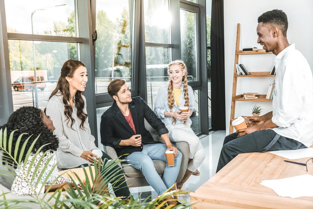 багатоетнічна група бізнес-партнерів, які розмовляють під час кавової перерви в офісі
 - Фото, зображення