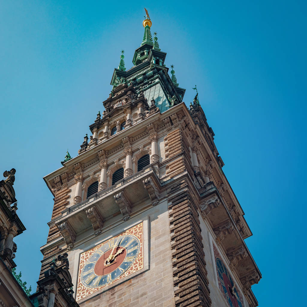Zegar wieży Rathaus na tle błękitnego nieba. Rathaus jest słynny Ratusz w Hamburgu, Niemcy. - Zdjęcie, obraz