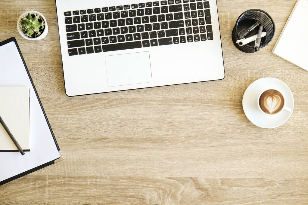 minimalistische flache Komposition mit schwarzweißer Laptop-Computertastatur, Tasse Kaffee mit herzförmiger Latte Art auf hölzernem Schreibtischhintergrund. Nahaufnahme, Draufsicht, Kopierraum. Kreativer Arbeitsplatz. - Foto, Bild