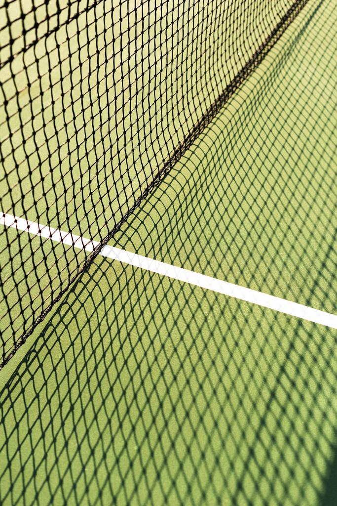 κλείνω πάνω θέα του net με σκιά στο πράσινο γήπεδο τέννις - Φωτογραφία, εικόνα