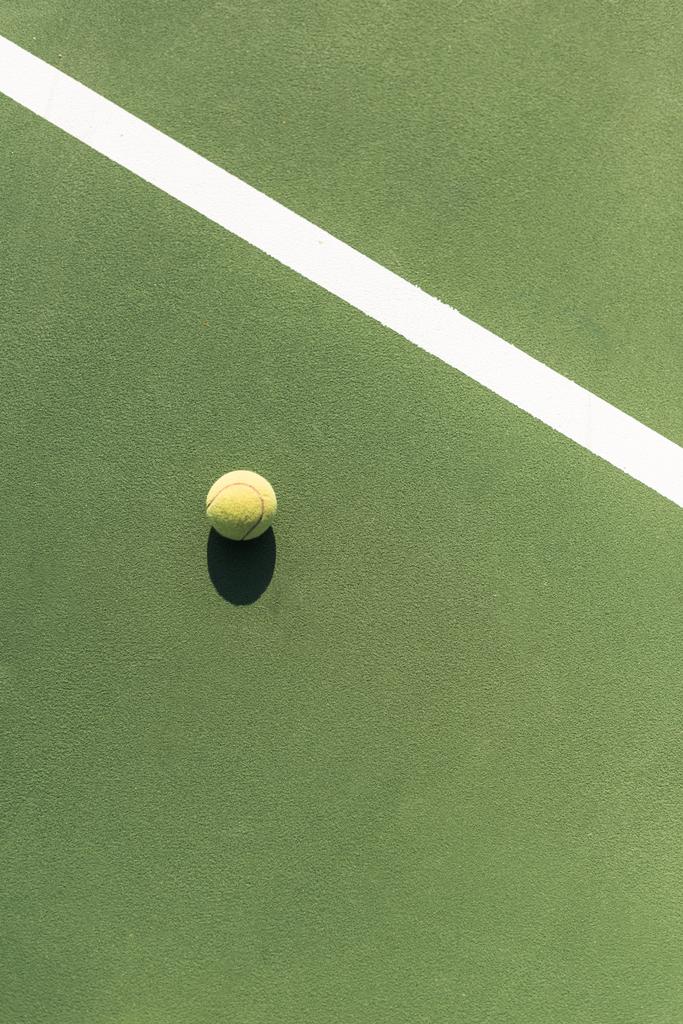 вид зверху тенісного м'яча на зеленому тенісному корті
 - Фото, зображення