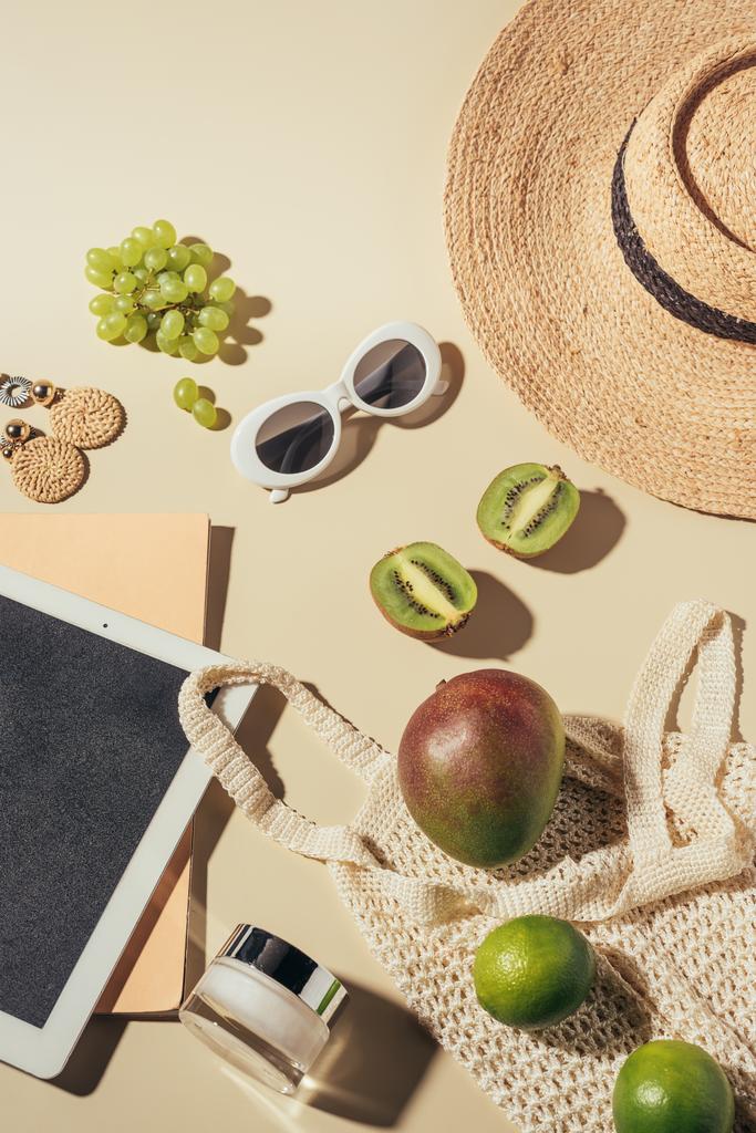 верхний вид солнцезащитных очков, шляпы, цифровой планшет и струнный мешок со сливками и свежими спелыми фруктами
  - Фото, изображение