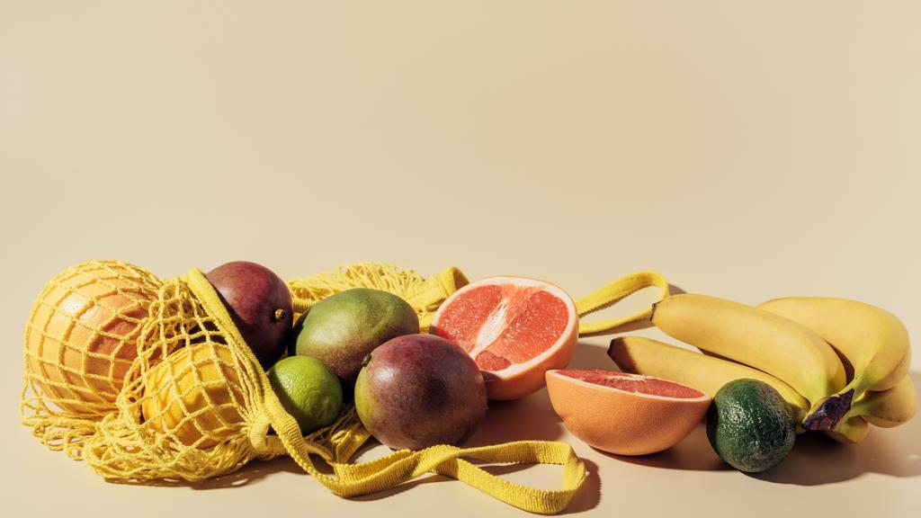 vista de cerca de frutas frescas maduras y bolsa de hilo en marrón
  - Foto, Imagen