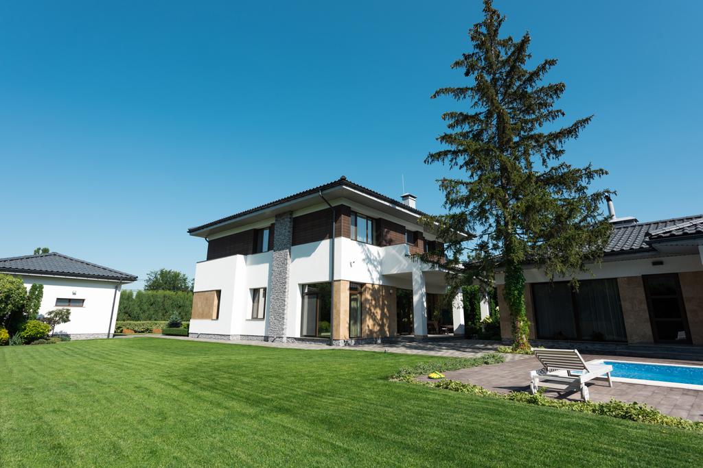 Blick auf neues modernes Haus mit Schwimmbad und grünem Rasen - Foto, Bild