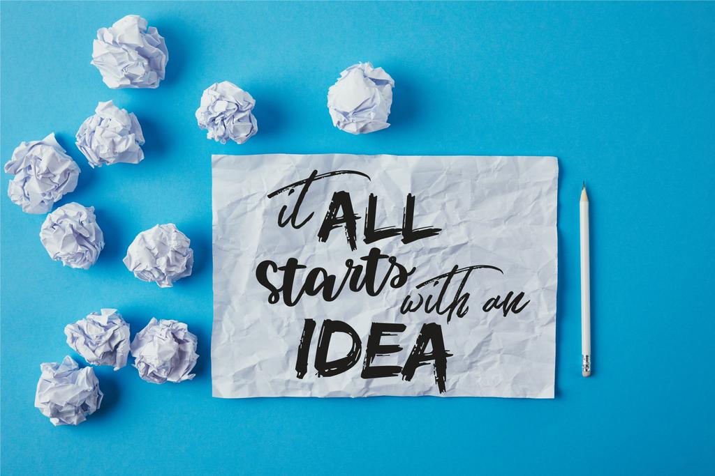 vue du dessus des papiers froissés et crayon sur la surface bleue avec "tout commence par une idée" inspiration
  - Photo, image