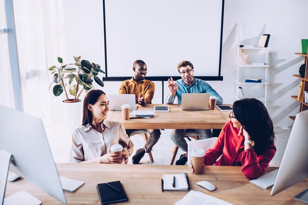 lachende Sex tussen verschillendre rassen jonge zakenlui te praten tijdens werken in office - Foto, afbeelding