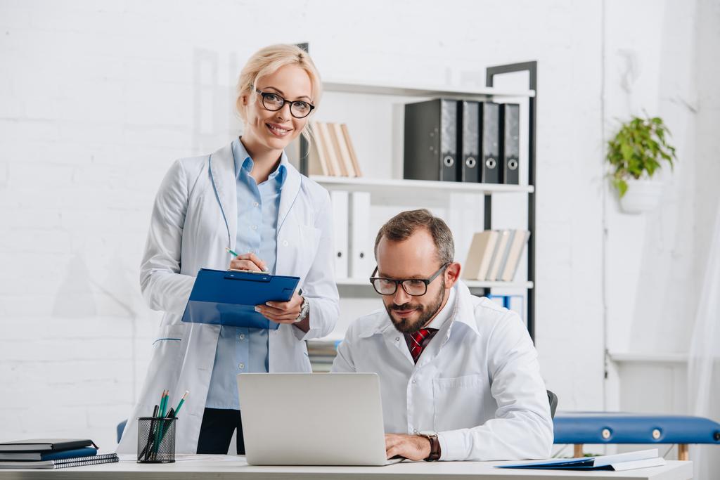 πορτρέτο του φυσικοθεραπευτές σε λευκό παλτό και γυαλιά στο χώρο εργασίας στην κλινική  - Φωτογραφία, εικόνα
