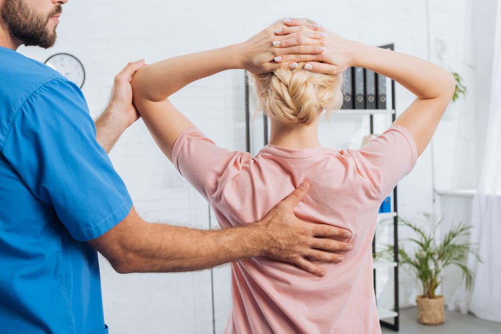 Schnappschuss von Physiotherapeutin, die Frau auf Massagetisch im Krankenhaus massiert - Foto, Bild