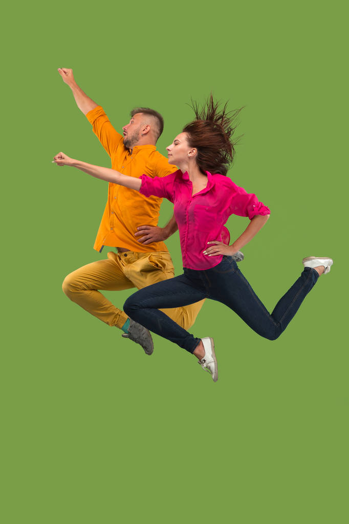 Liberté de mouvement. Jolie jeune couple sautant sur fond vert
 - Photo, image