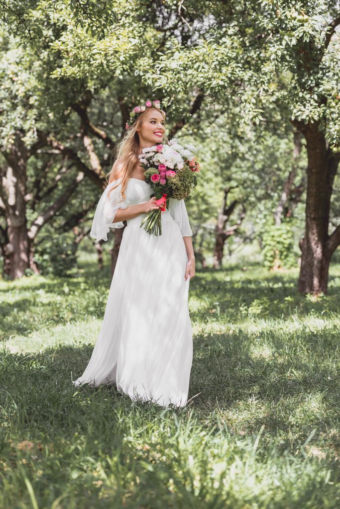 красивая счастливая молодая невеста с свадебным букетом и прогулкой в парке
  - Фото, изображение