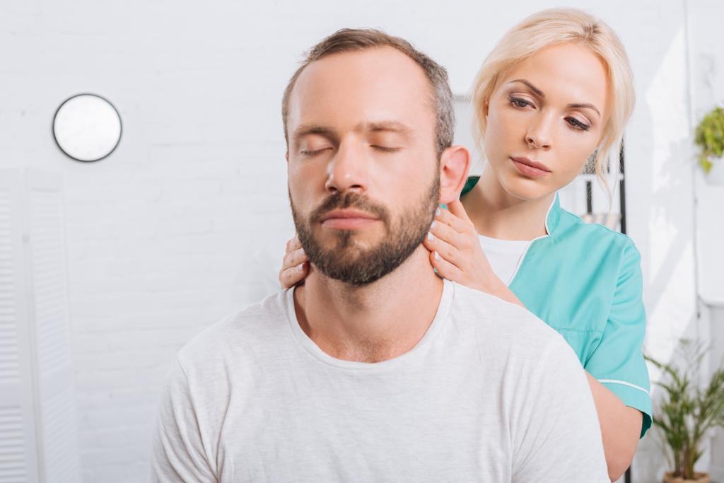 retrato de fisioterapeuta massageando homem pescoço na clínica
 - Foto, Imagem