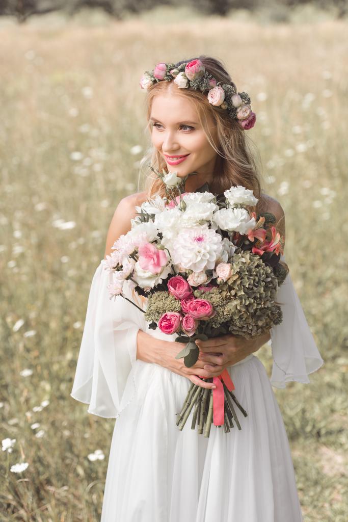 красивая улыбающаяся молодая невеста держит свадебный букет и смотрит на улицу
  - Фото, изображение