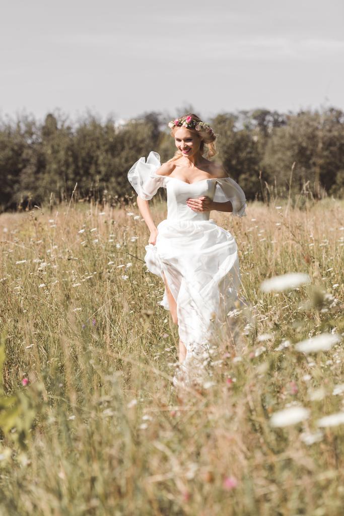 hermosa novia joven feliz en vestido de novia corriendo en el campo
  - Foto, imagen