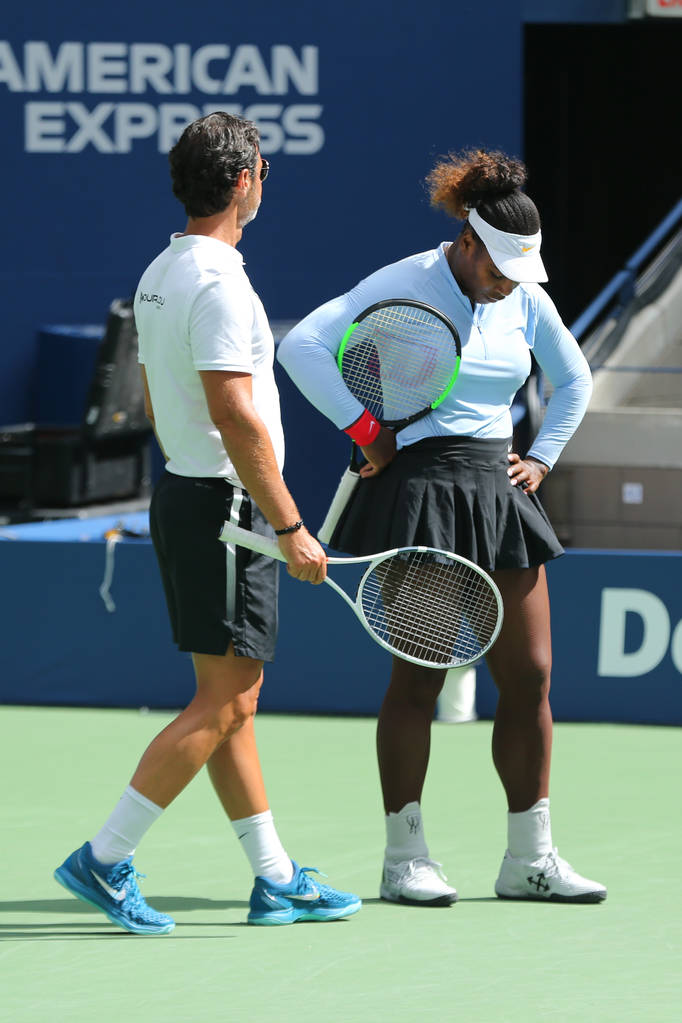 NOVA IORQUE - 23 de AGOSTO de 2018: A campeã do Grand Slam Serena Williams conversa com seu treinador Patrick Mouratoglou durante o treino no Aberto dos EUA de 2018 no Billie Jean King National Tennis Center
 - Foto, Imagem