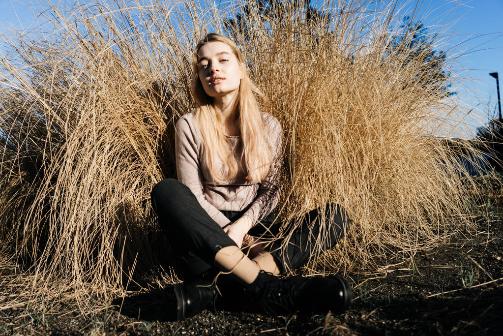 elegante jovem loira modelo menina posando na grama no sol
 - Foto, Imagem
